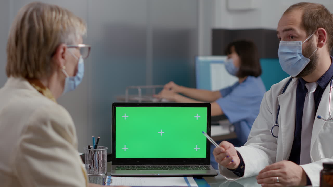 Elder person looking at greenscreen on laptop at checkup visit