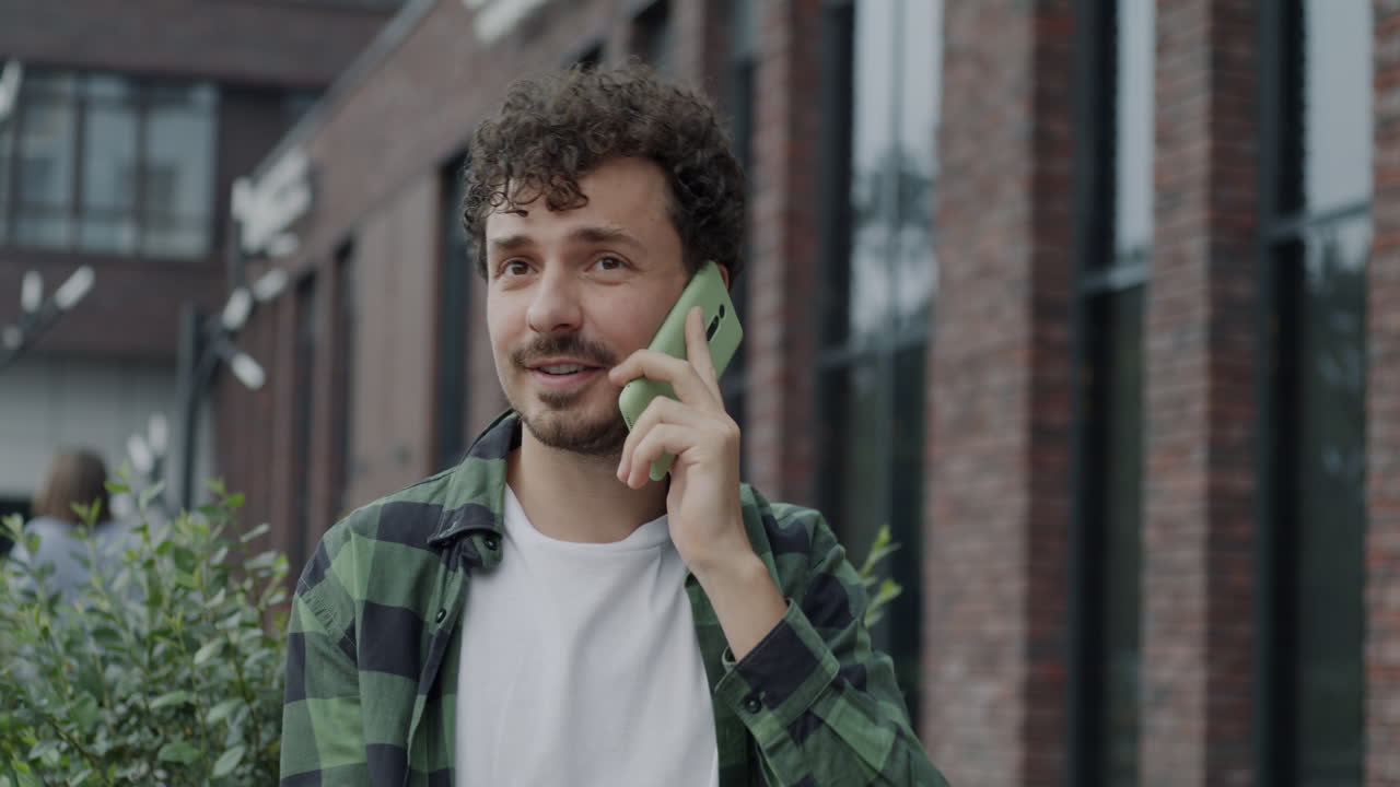 мужчина разговаривает по телефону на улице