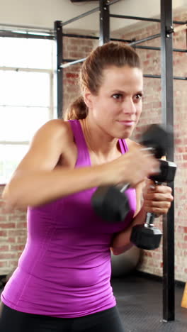 fit people lifting heavy black dumbbells