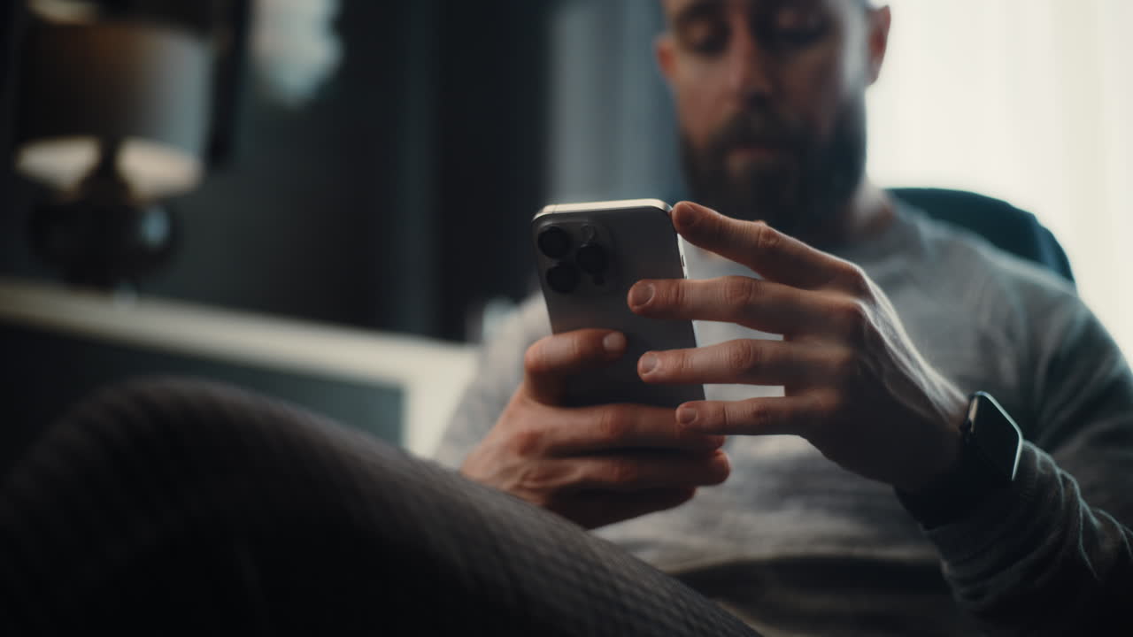 Close Up of Financial Expert Working on Smartphone, Monitoring Real-Time Stocks and Exchange Market Charts, Making Investments. Successful Businessman Works in Comfortable Office of Investment Bank.