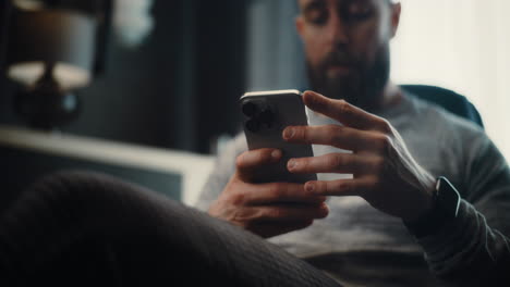close up of financial expert working on smartphone, monitoring real-time stocks and exchange market charts, making investments. successful businessman works in comfortable office of investment bank.