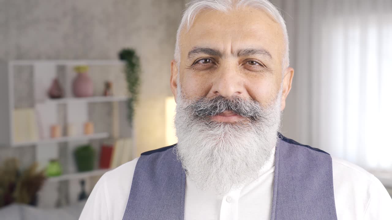 un hombre maduro sonriente y comprensivo mirando a la cámara.