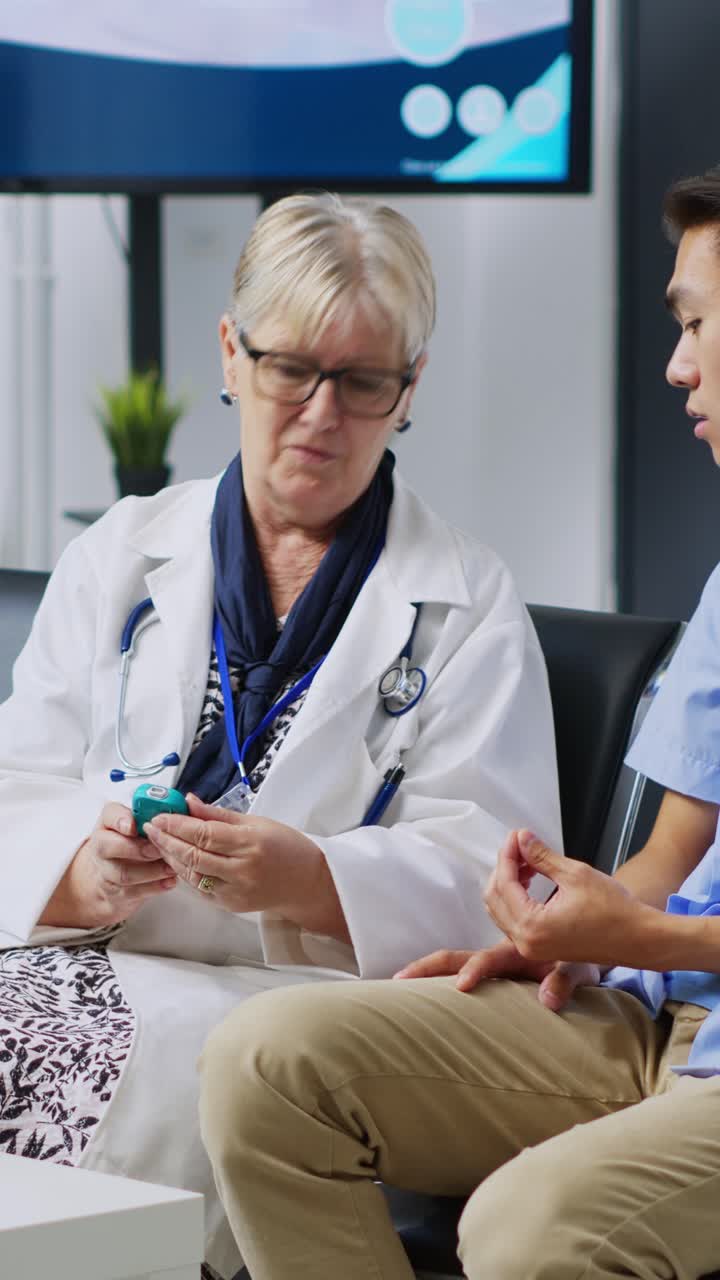 Vertical video: Elderly medic measuring glucose level