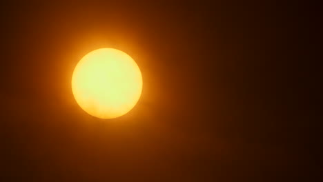 close up of the sun with thin hazy clouds moving in front