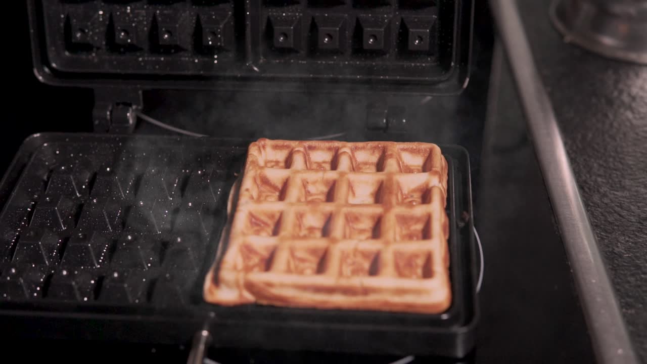 Opening waffle with the already prepared dough, healthy cooking and fitness, slow motion in traditional kitchen