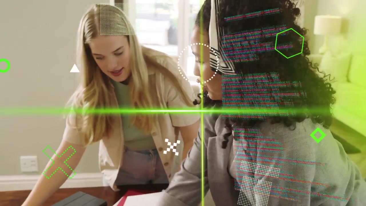 Two women leaning over table picking charts and causing green overlay, sorting tablet for business