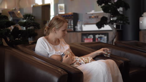 mother breastfeeding baby in hotel hall