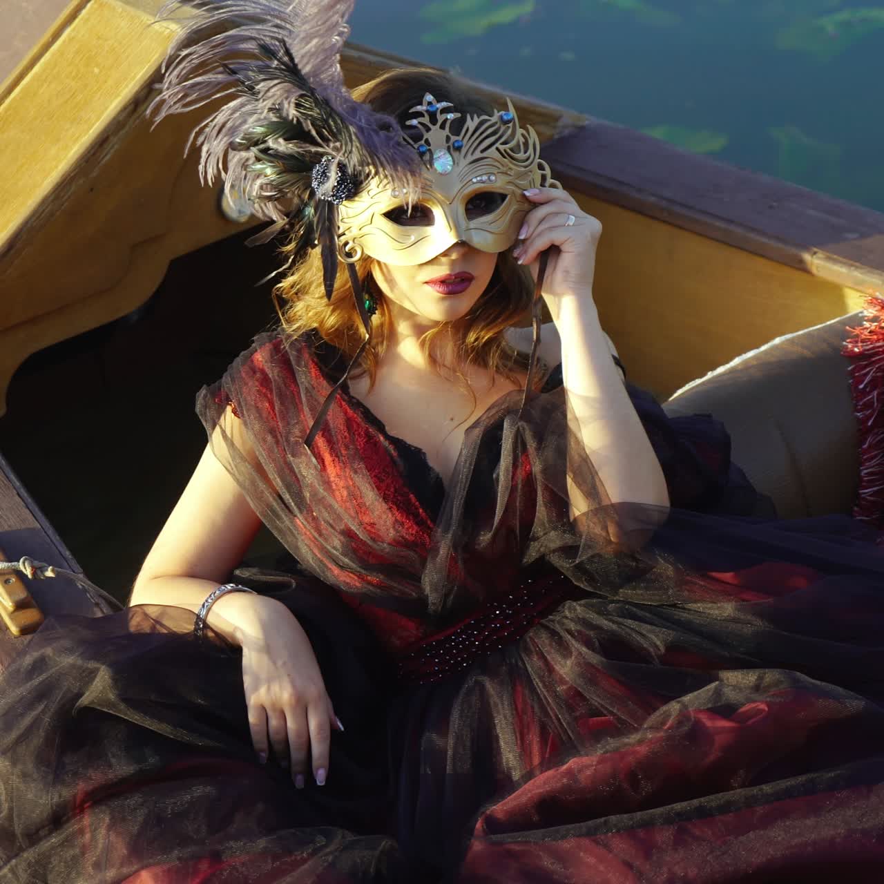 Young woman in gondola. Beautiful woman in a carnival mask