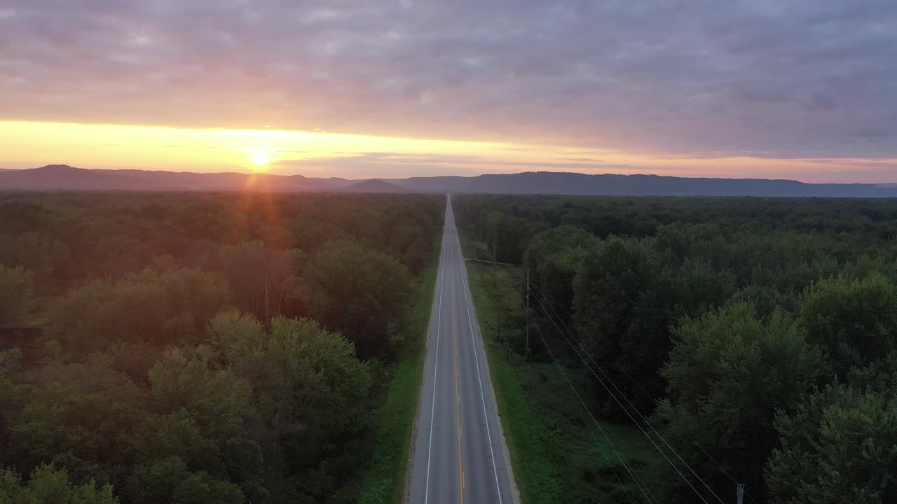 amanecer sobre un camino de campo a través de un bosque