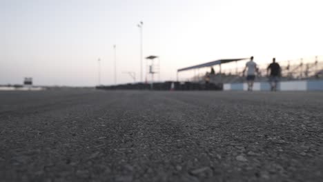 dos personas caminando en una pista de carreras vacía