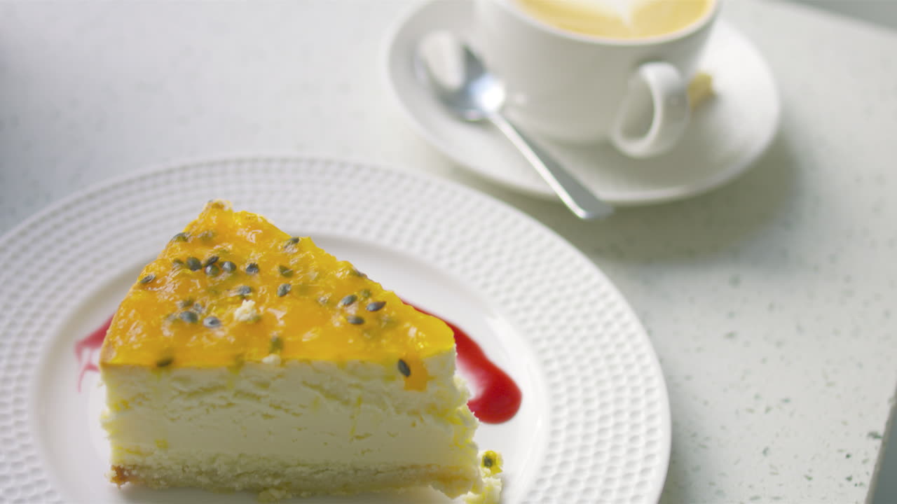 красивый парень сидит в кафе, читает книгу, пользуется мобильным телефоном и пьет кофе