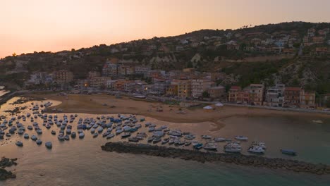 pan drone view of marina di palma with boats parked on beach in sicilia during sunset