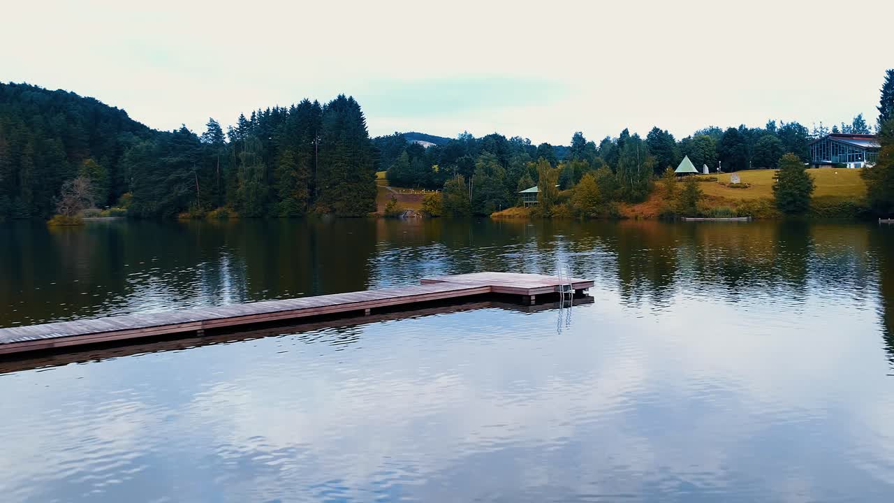 небольшой пирс посреди озера в окружении живописной природы