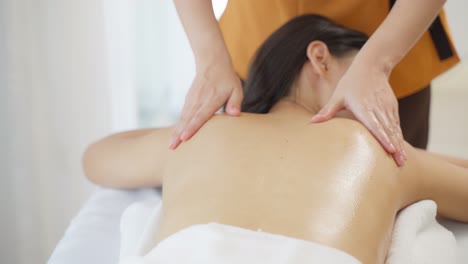 una mujer recibiendo un masaje de espalda en un spa.