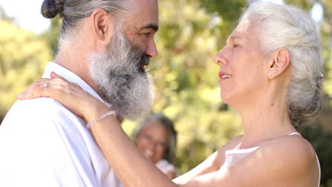 senior bride and groom dancing at outdoor wedding, smiling and enjoying each other's company