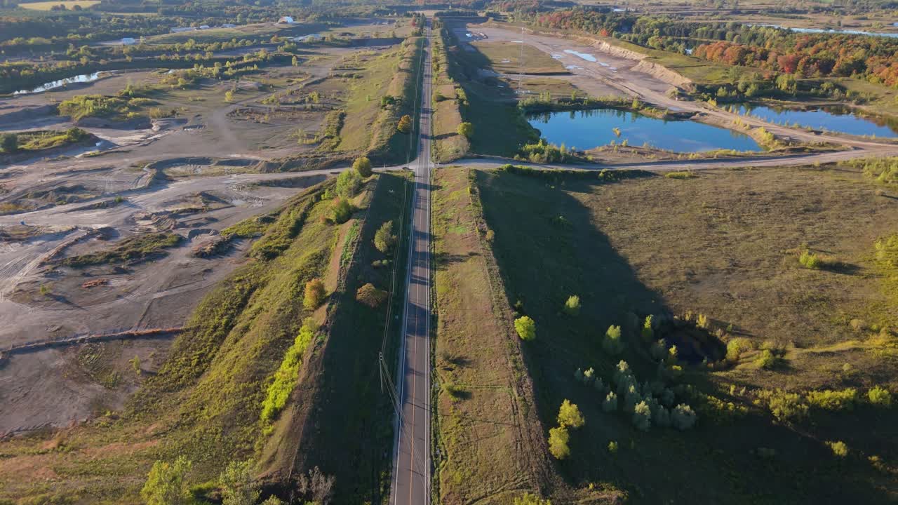 Aerial drone footage showing a gravel pit located alongside a long rural road in Caledon Village, Ontario, Canada