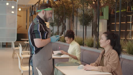 waiter taking order from asian woman