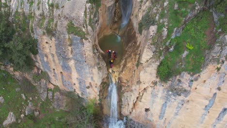 climbers next to precipice and waterfall ready for rappelling