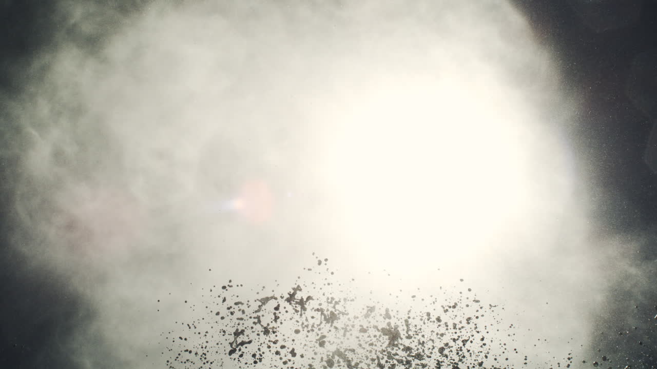 Midnight blowhole eruption captured with misty particles bursting upward in dark silhouette