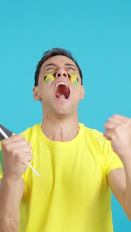 man cheering for jamaica screaming and waving a national flag