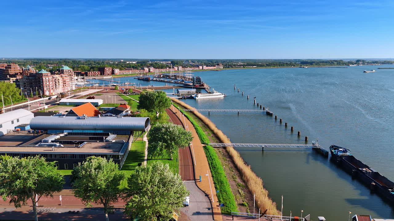 Flying over the museum Batavialand in Lelystad, the Netherlands. Beautiful green lakefront and peaceful waterscape from drone footage.