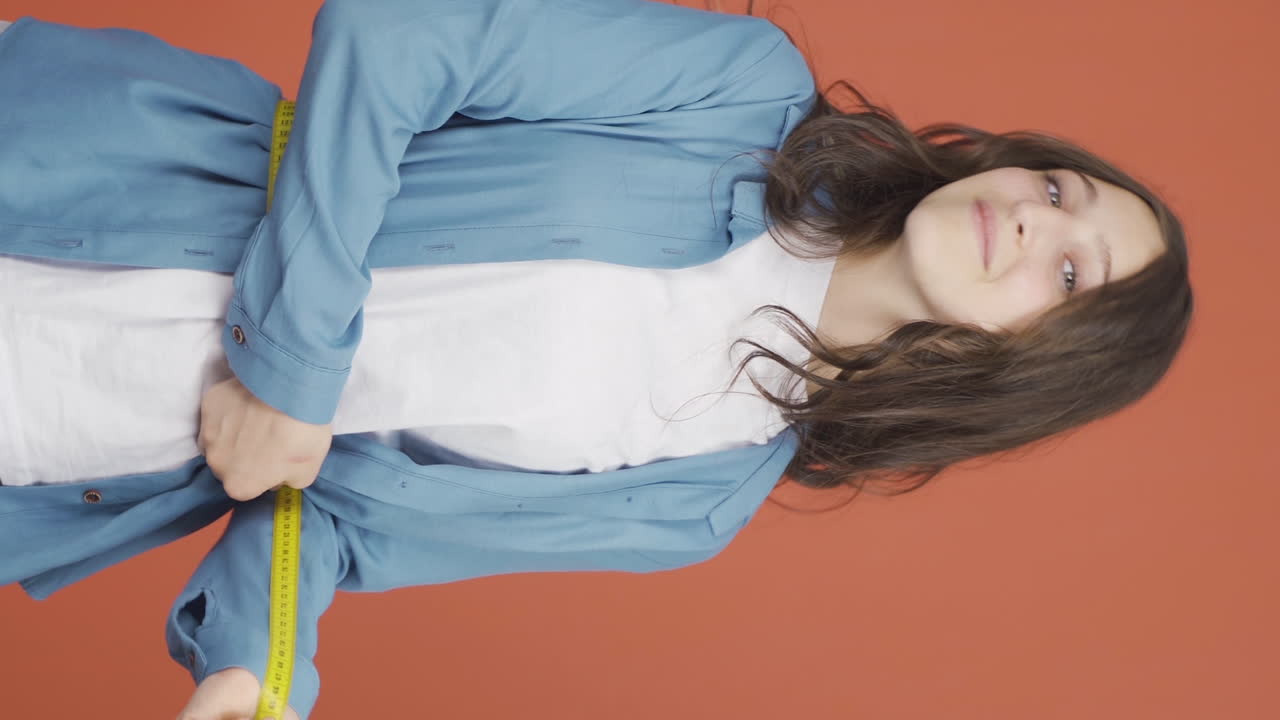 자신의 몸무게에 만족하는 젊은 여성의 수직 비디오.