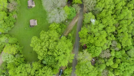 Birds-eye-view-over-a-small-road-with-tents-and-campers-on-both-sides-of-the-road-in-Wisconsing,-USA