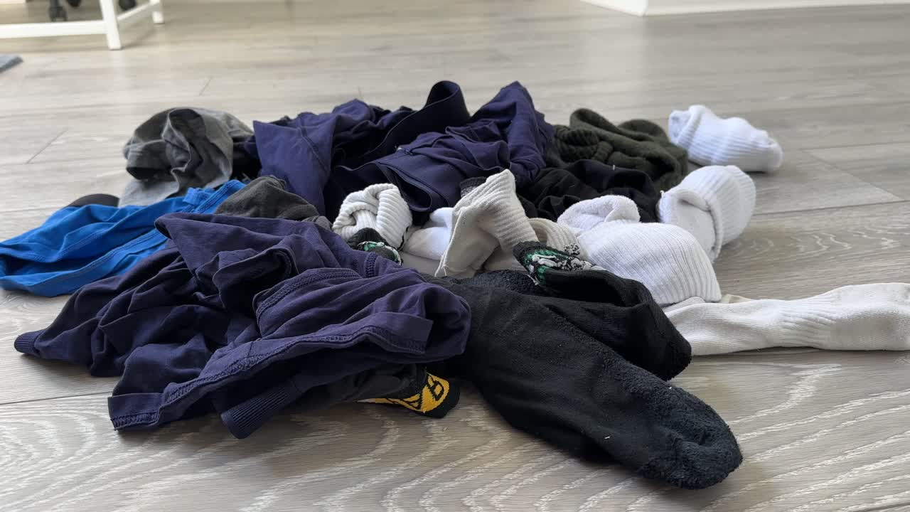 Pile of dirty pair of socks underwear boxer shorts on the bedroom floor laundry