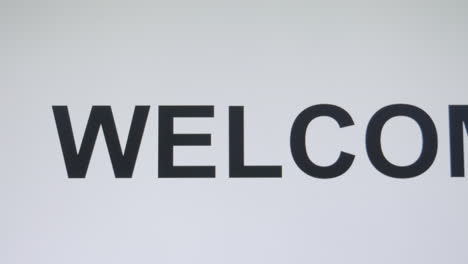 digitally typing the word welcome in an upper case font, with the use of a keyboard of a computer