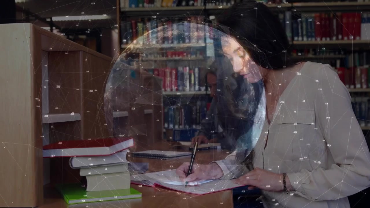Uno studente prende appunti in una postazione di studio, attivando un globo educativo rotante che mostra un compagno che legge un libro di testo.