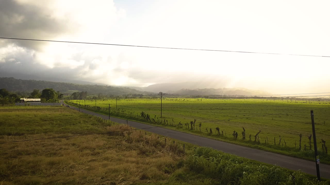 열대 화산 근처 시골길을 달리는 자동차