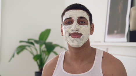 portrait of a handsome black male with facial mask looking at camera and smiling