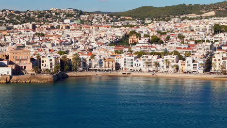 Drone-captures-charming-old-sailors'-town-in-sunny-weather-with-a-beautiful-blue-sea-coast-backdrop