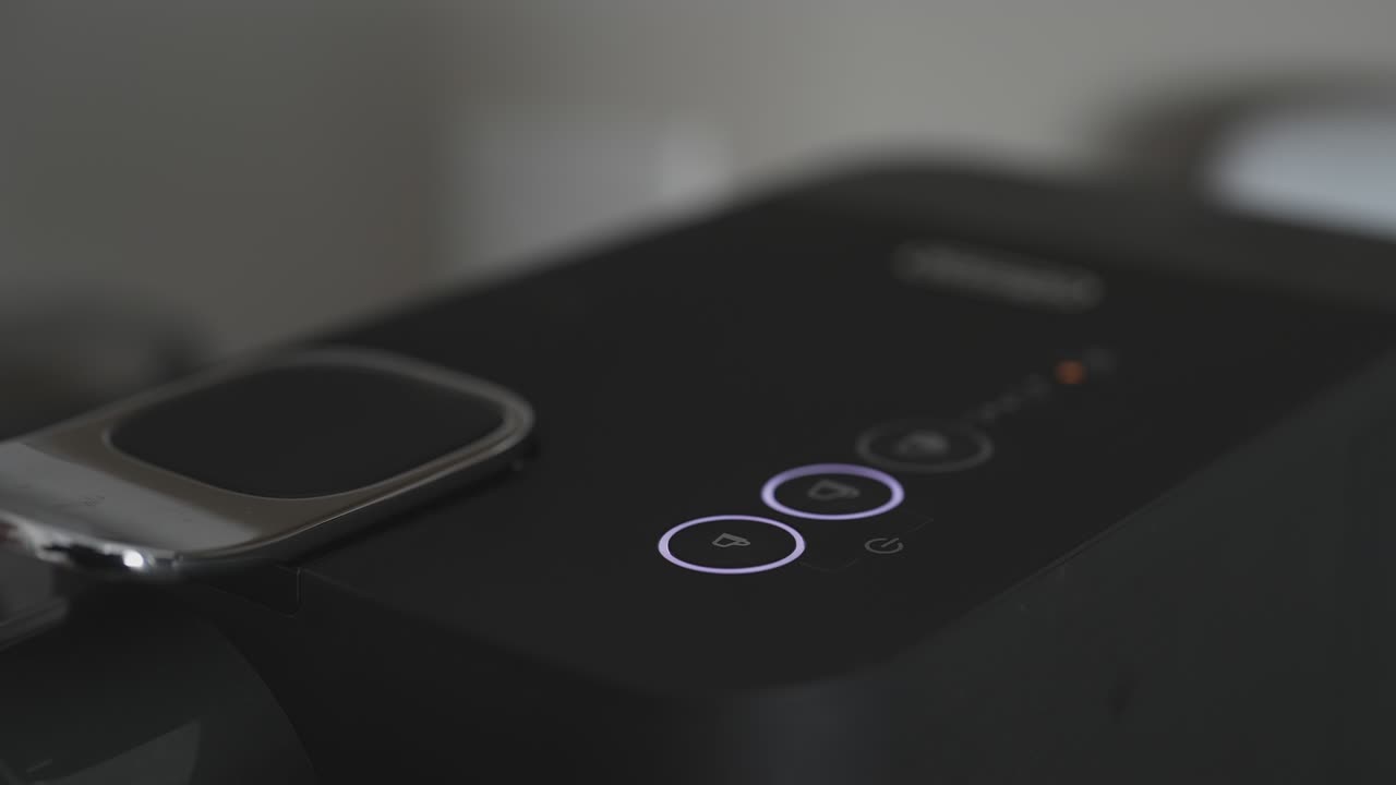 la mano presionando el botón de la máquina de café