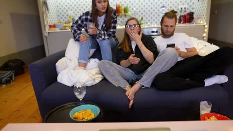amigos viendo la televisión y pasando el rato en un sofá
