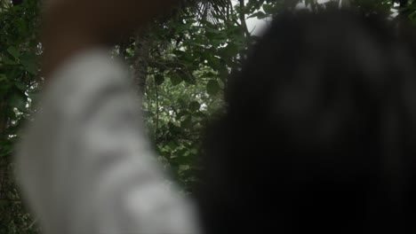 camera captures the background scenery as a young woman stretches her arms, her back facing the camera in a white t-shirt