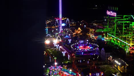 drone-shot-of-the-theme-park-Winter-Wonderland-in-Hady-park-in-London,-United-Kingdom-at-night