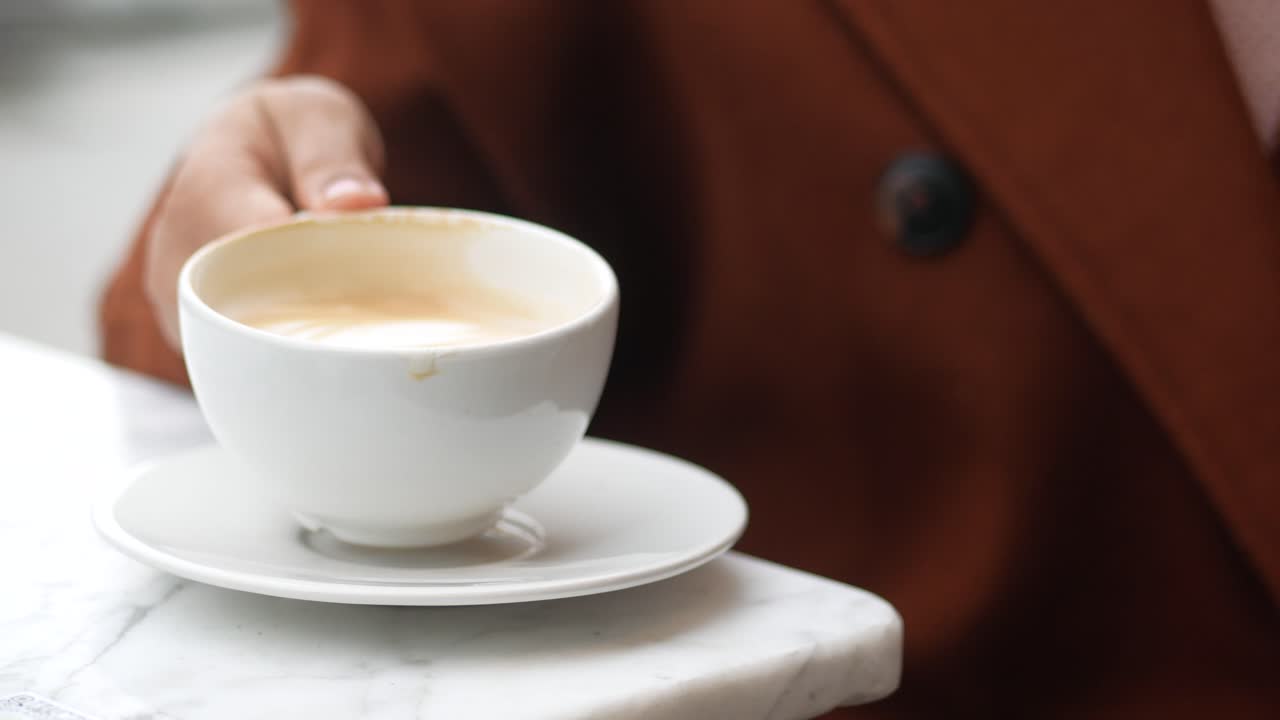 mujeres sosteniendo una taza de café en la mesa ,