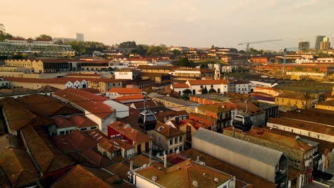 Gondola-of-Teleférico-de-Gaia-driving-over-city-of-Porto-during-sunset-time-in-Portugal---aerial-view