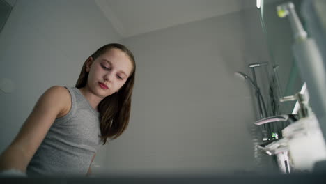 girl applying makeup in bathroom