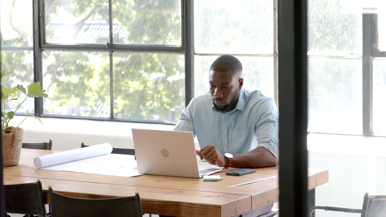 Working on laptop, man in office focusing on business tasks at desk