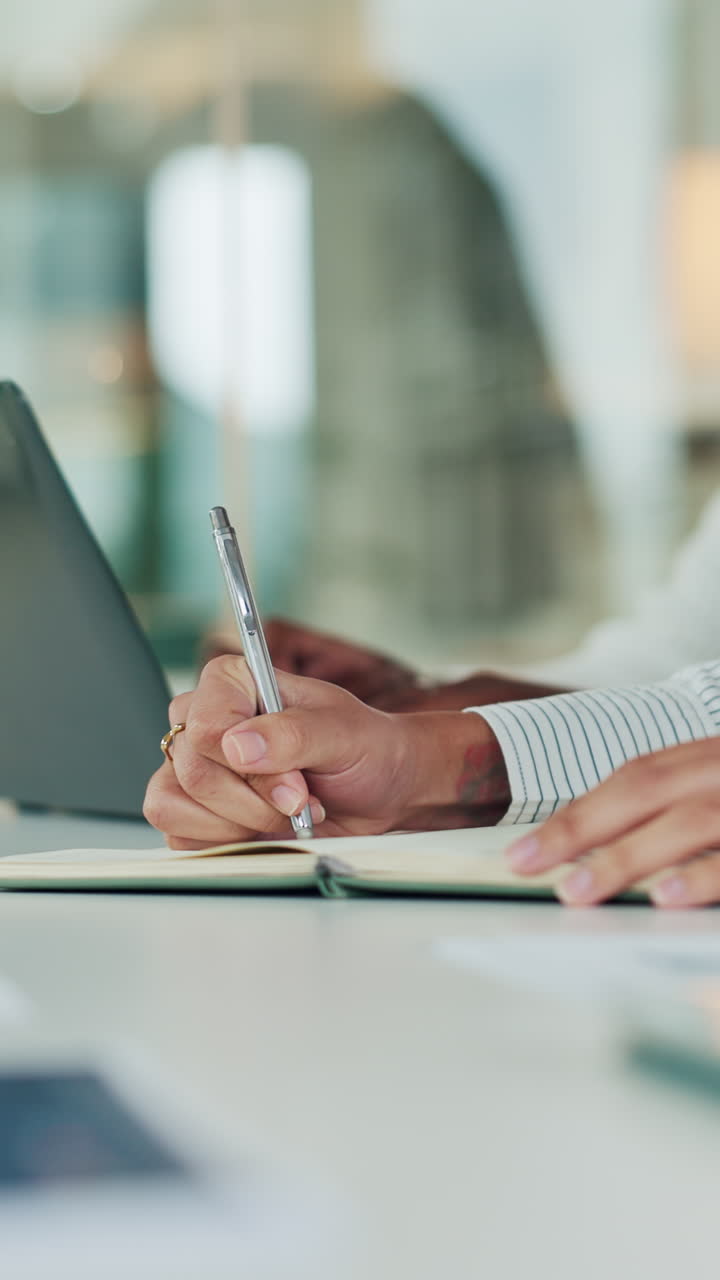Persona che scrive in un quaderno a una scrivania