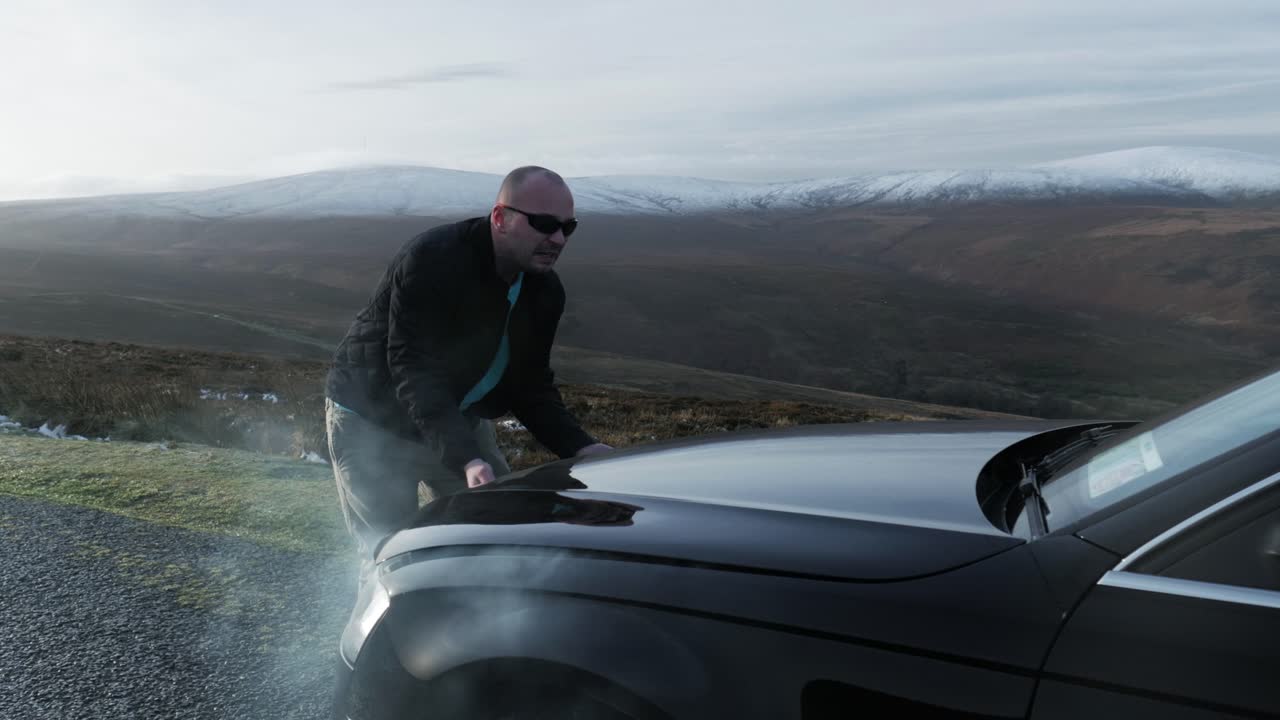 серый дым под капотом застрявшего на обочине автомобиля