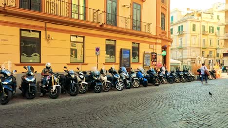 turistas y scooters en una calle bulliciosa