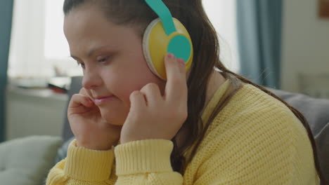 girl with down syndrome listening to music with wireless headphones