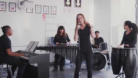 estudiantes de la escuela de artes escénicas tocando en la banda en el ensayo