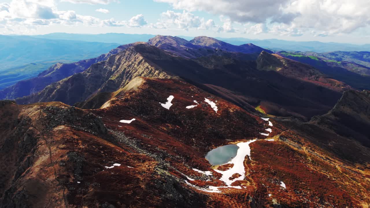 Stunning aerial view of the Dolomites, showcasing rugged peaks and snowy patches