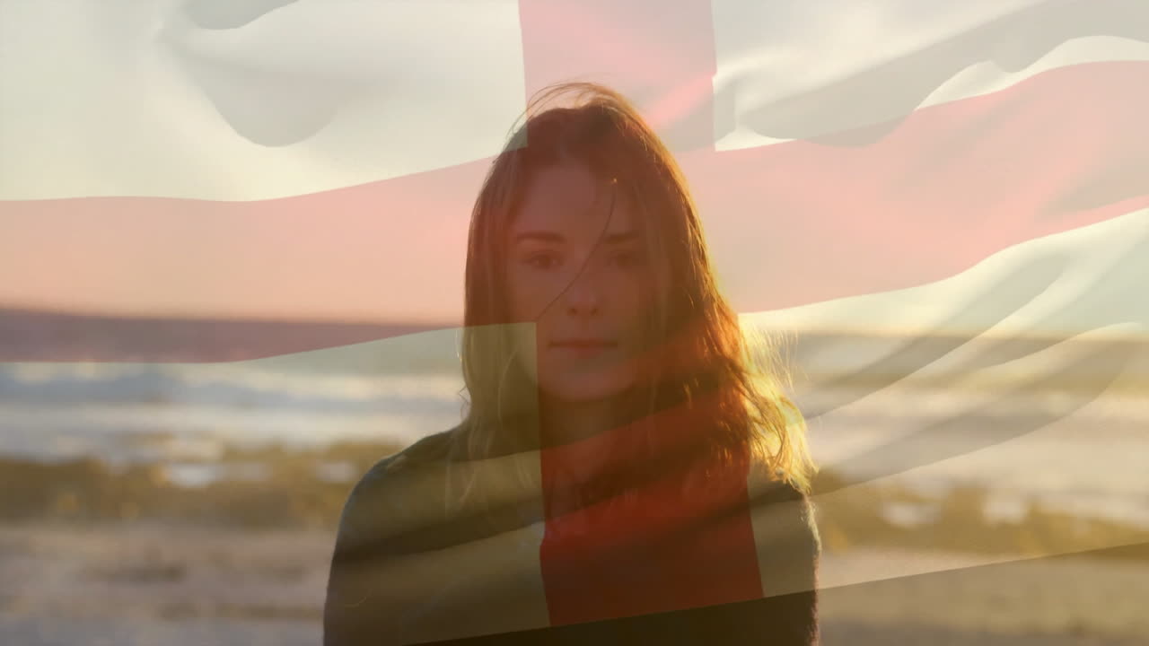 At beach, woman standing with British flag overlay in warm sunlight animation