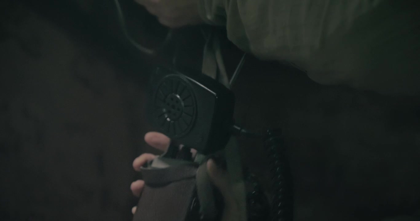 Man collects vintage radio communication equipment inside a dark wartime bunker, creating a cinematic scene evoking historical military communications.