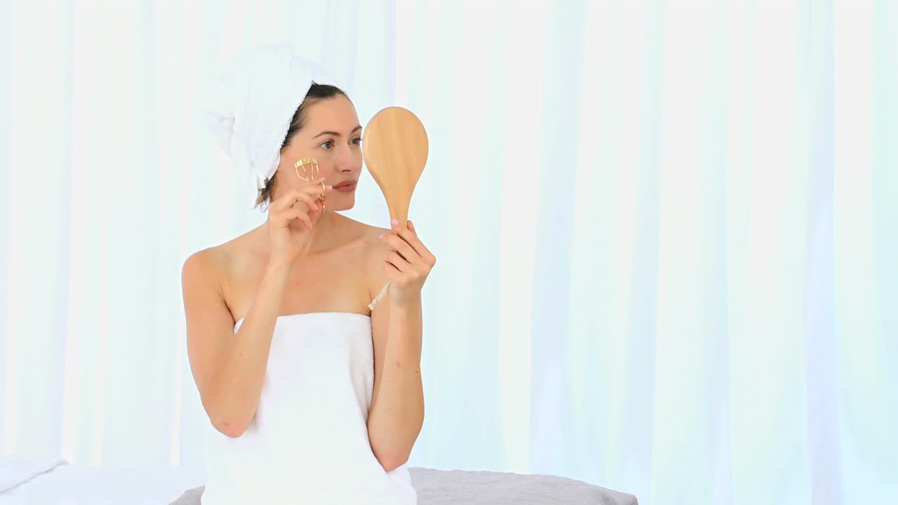 Brunette curving her eyelashes 